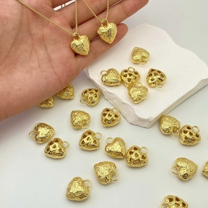 Detail of gold heart pendant featuring a hammered texture and cutout heart design