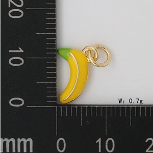 Détail macro du mini pendentif banane montrant la taille de 15 mm avec une règle
