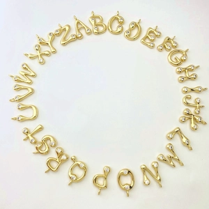 Macro shot of 26 gold plated alphabet letter pendants with sparkling zircon stone inlay