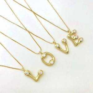 Detailed macro view of gold letter pendants L-O-V-E set with sparkling zirconia stones