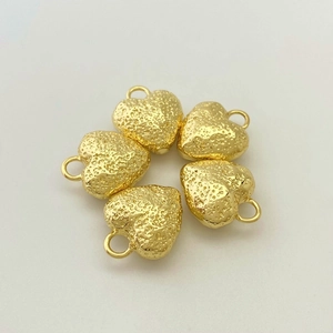Detailed macro view of five gold heart pendants with unique molten lava texture and small ring