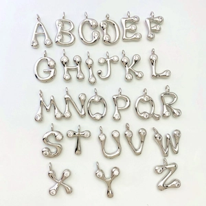 Close-up of 26 alphabet pendants with cubic zirconia inlay in silver finish