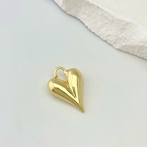 Detail of a gold 3D heart pendant with unique vertical pleated texture and mirror finish