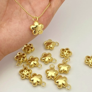 Detailed macro view of gold flower pendants with embossed textured petals on fine chain