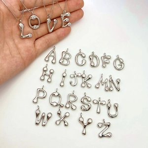 Detailed set of 26 silver alphabet pendants with white zircon inlays and round design
