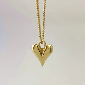 Close-up of a polished gold heart pendant with a fine box chain necklace for women