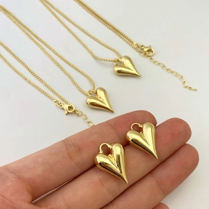 Detailed view of the 3D puffed heart pendant on a delicate gold-plated cross chain