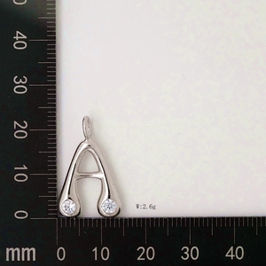 Detailed view of silver letter A pendant with zircon on measuring scale showing 18mm height