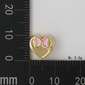 Vista macro di un ciondolo a cuore rosa da 10mm con pois su scala metrica