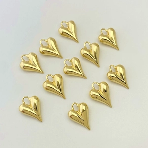 Close-up of high-polished gold heart-shaped pendants with minimalist artistic twists