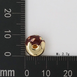 Vista macro del ciondolo a ciambella dorata da 10mm con glassa al cioccolato e pois