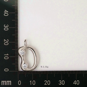 Detailed scale measurement showing a letter D pendant with clear cubic zirconia stones