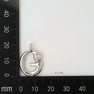 Detailed scale measurement of polished silver letter G pendant with clear zircon stone
