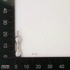 Detailed size view of silver letter pendant with cubic zirconia next to a measurement ruler