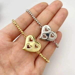 Detail of beaded heart bracelets in gold and silver with zircon inlaid MOM pendants