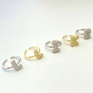 Detail of adjustable letter rings with micro-pave zirconia in gold and silver finish
