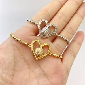 Detail of gold and silver heart bracelets with ladybug charms and zircon stones