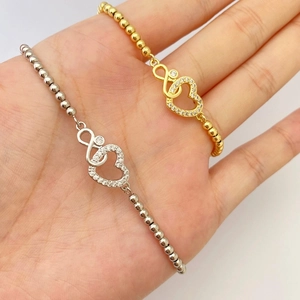 Detailed shot of gold and silver MOM heart infinity bracelets with micro-pave crystals