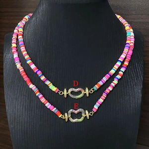Bunte Heishi-Perlenkette im Boho-Stil mit Herz-Zirkonia-Verschluss auf einem schwarzen Büste
