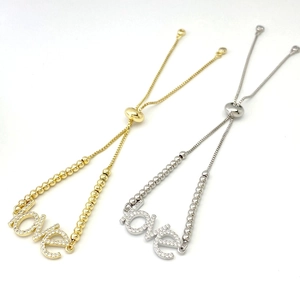 Macro shot of adjustable MOM letter bracelets in gold and silver with zircon accents