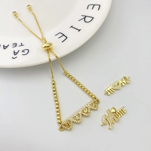 Detailed macro of gold-plated adjustable bracelet with sparkling MAMA MOM MUM heart charms