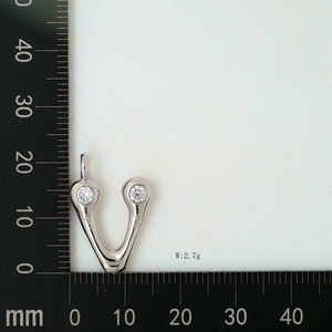 Macro shot of silver V letter pendant with zircons showing dimensions of 17mm by 15mm