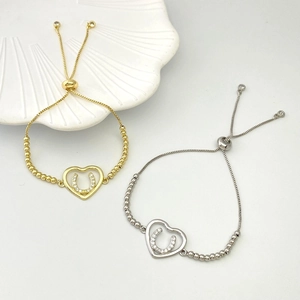 Detail of adjustable heart bracelets in gold and silver with horseshoe stone settings