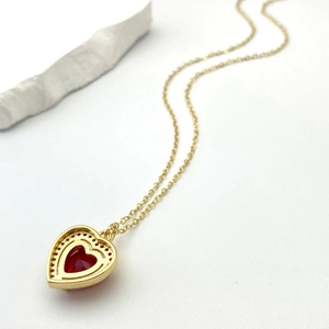 Dettaglio della collana con pendente a cuore dorato con cristallo rosso e micro-pavé