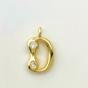 Macro shot of gold-plated letter D pendant with minimalist zircon droplet design