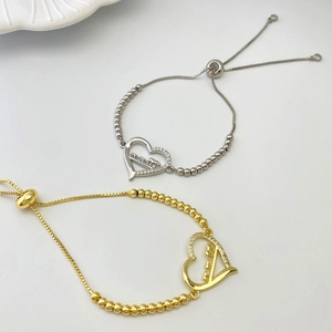 Detail showing adjustable silver and gold MOM bracelets with diamond heart charms