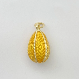 Détail du pendentif œuf en émail jaune avec texture nid d'abeille et placage en métal doré
