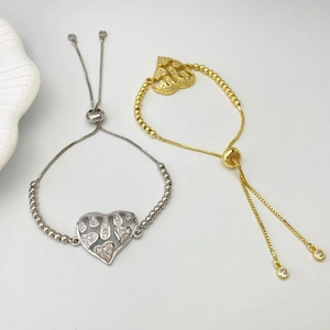 Close-up of adjustable bead bracelets with heart Allah pendants in gold and silver