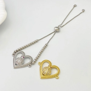 Detail of adjustable silver beaded bracelet and ladybug heart charm with white crystals