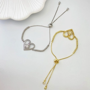 Detail of adjustable heart bracelet with ladybug charm in silver and gold finish