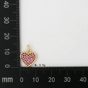 Dettaglio macro di un ciondolo a cuore in oro da 0,9g con pavé di zirconi rosa e scala