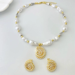 Detail of seashell jewelry set with baroque pearls and gold spiral shell pendants