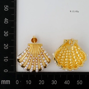 Detailed macro view showing dimensions of golden scallop shell earrings with white pearls