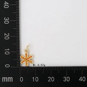 Dettaglio di un piccolo ciondolo a fiore oro e arancione con peso di 0,57 g