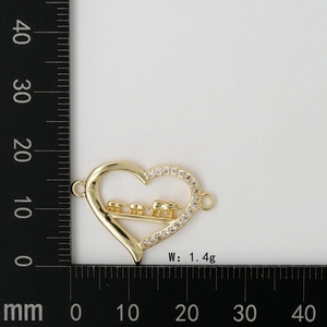 Macro view of gold heart MOM charm with bears and zircons on measuring scale