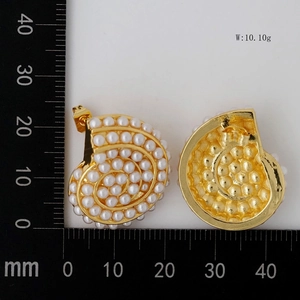 Detailed view of gold nautilus shell earrings with white pearls, weighing 10.10g