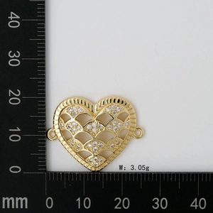 Detailed macro view of heart-shaped gold charm with MOM engraving and crystals