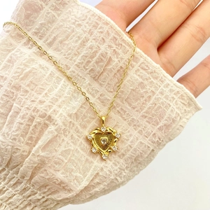 Golden heart-in-heart pendant necklace featuring sparkling cubic zirconia on a delicate O-chain