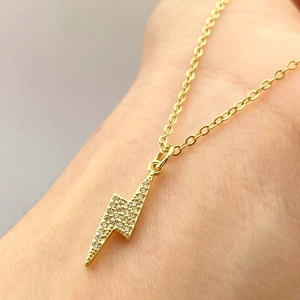 Collana con ciondolo a fulmine in oro micro-pavé di zirconi indossata sul collo