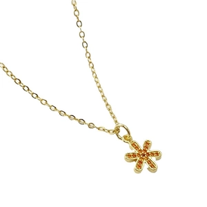 Collana minimalista in oro con pendente a fiore esagonale e pietre di zircone arancione