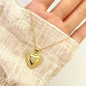 Detailed macro of gold heart pendant necklace with shimmering zircon stones on lace
