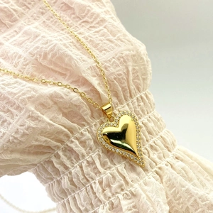 Close-up of heart pendant with sparkling cubic zirconia border on a gold necklace