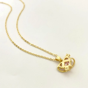 Macro detail of gold-plated crown planet pendant with pink zircon and hollow structure