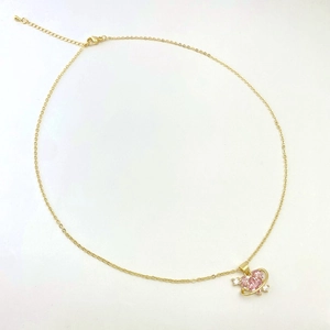 Detailed macro view of heart planet pendant necklace with pink zircon and golden chain
