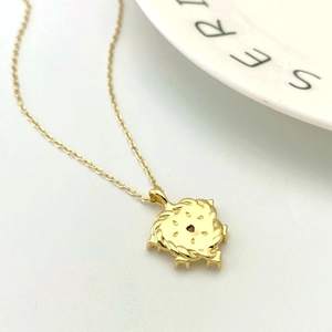 Detail of a golden openwork circular pendant with twisted rope edges on a fine cross chain