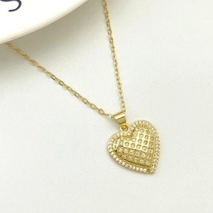 Detailed macro of golden heart pendant necklace with shimmering zircon lattice patterns